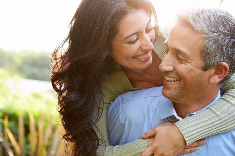 things that can improve your relationship based on your zodiac sign, couple hugging, couple smiling