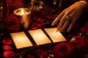 Three glowing tarot cards by candlelight with roses, three tarot cards that show up when real love is near
